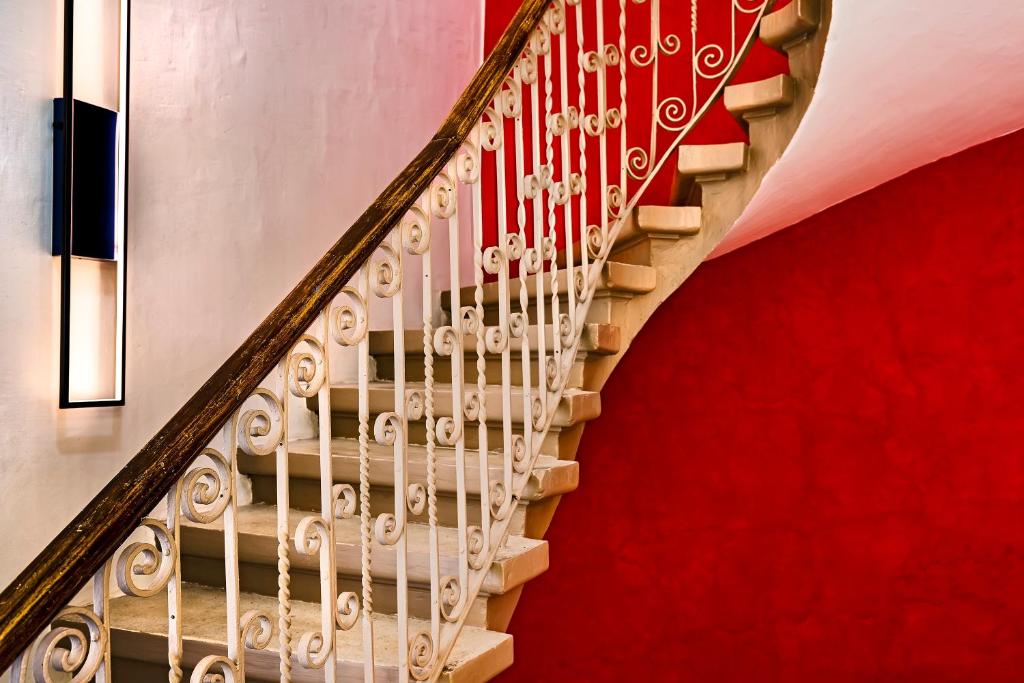 a stairway with a red wall and a red carpet at The Snop House in Senglea