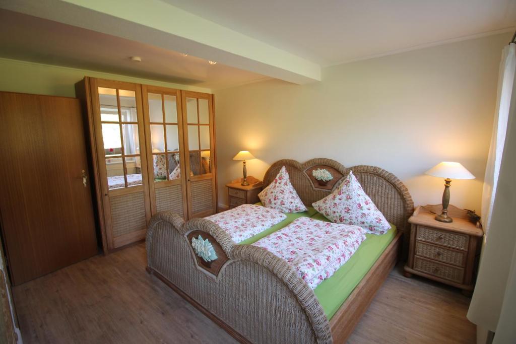 Un dormitorio con una cama de mimbre con almohadas. en Immenhagen Ferienwohnungen en Malente