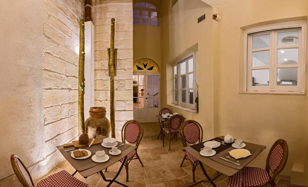 a dining room with two tables and chairs and a window at The Snop House in Senglea