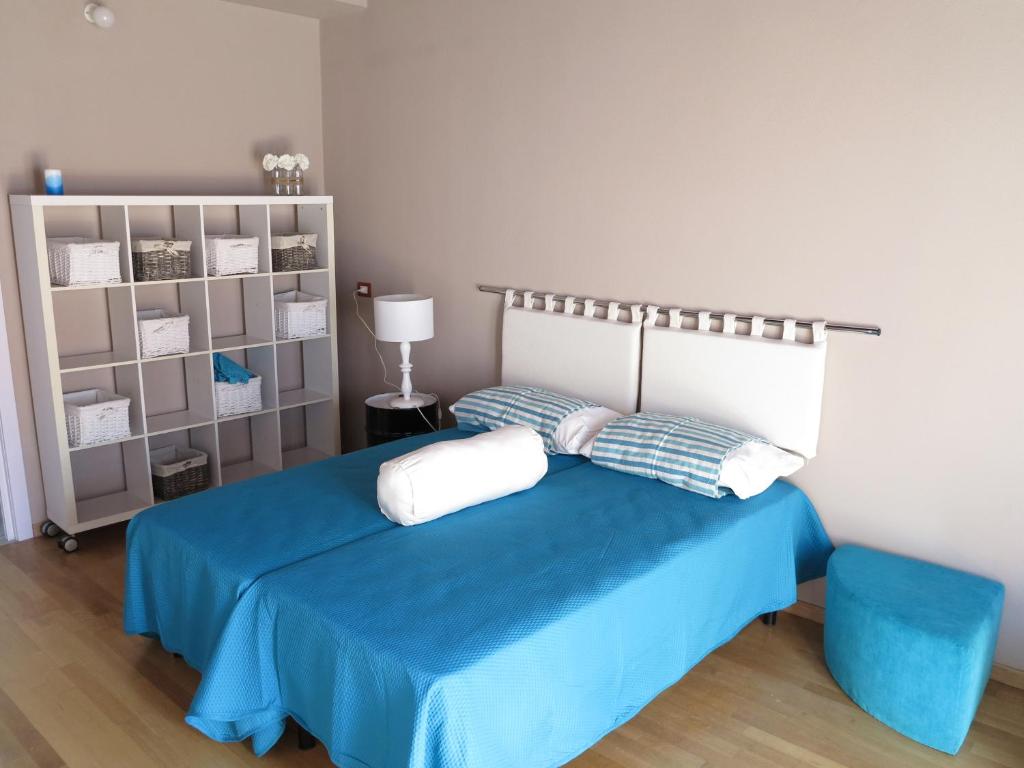una camera con un letto blu e una sedia blu di Original b&b a Porto Torres