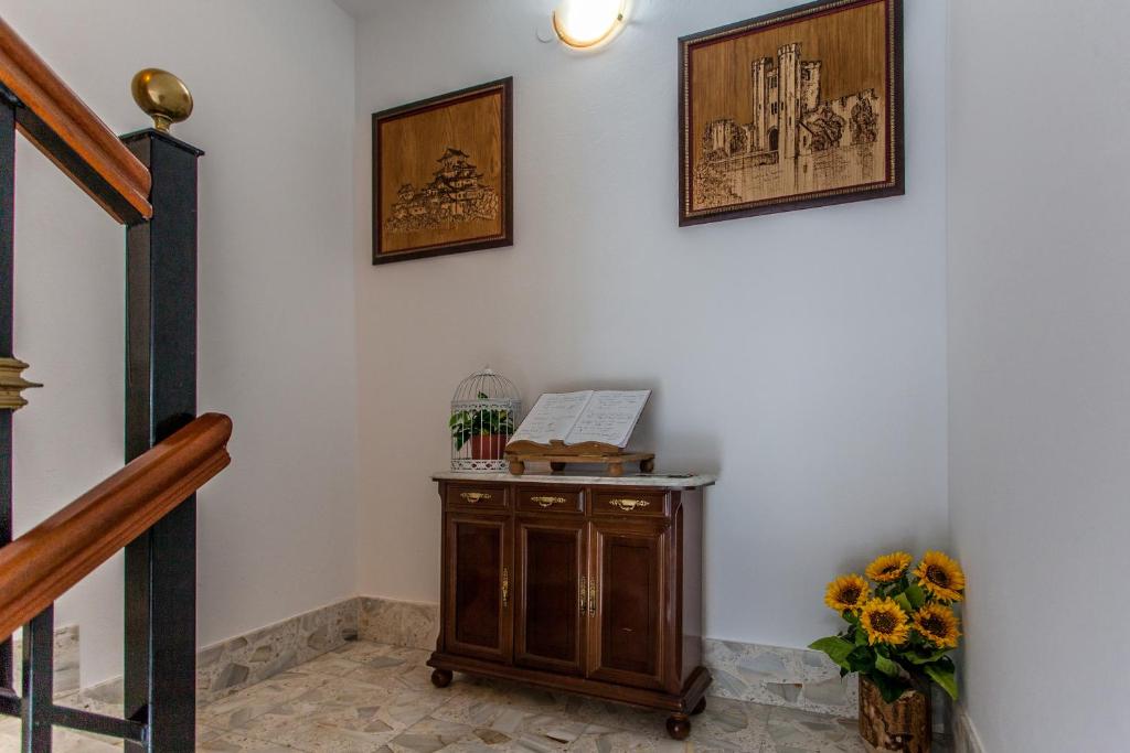 a staircase with a wooden cabinet and pictures on the wall at O Castelo in Palas de Rei