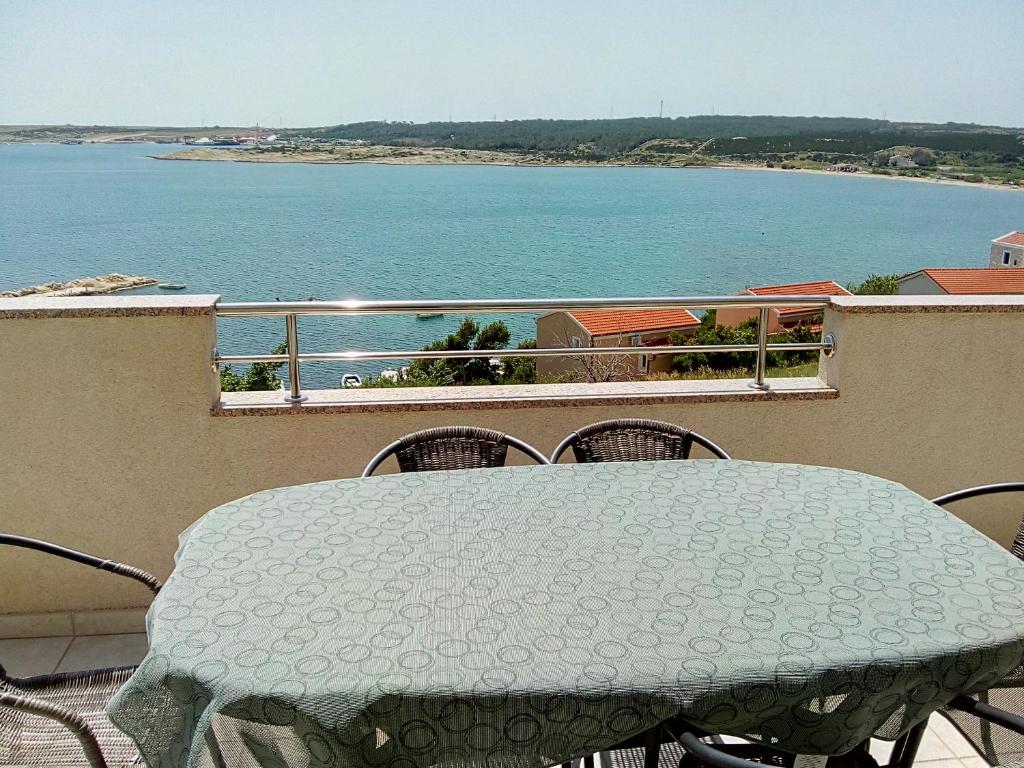 a table on a balcony with a view of the water at Apartmani Luna in Novalja