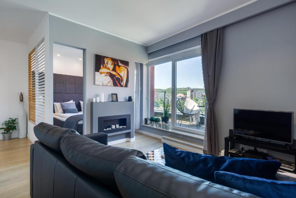 sala de estar con sofá y chimenea en Elite Apartments Chmielna Deluxe en Gdansk