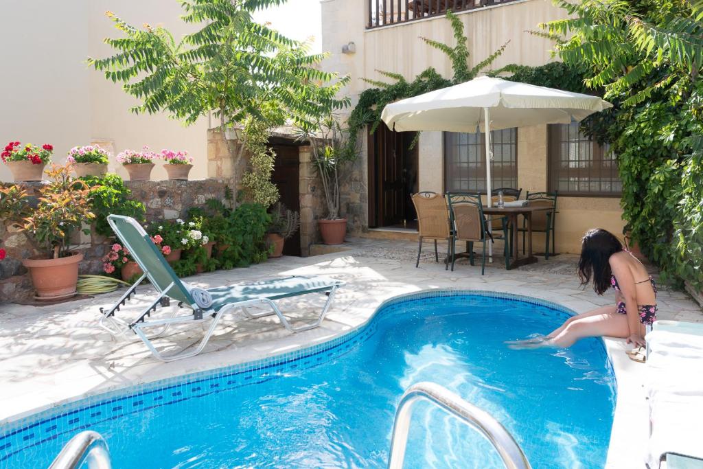 una mujer está saltando a una piscina en Ariadni Stone House with private pool, en Kolimvárion