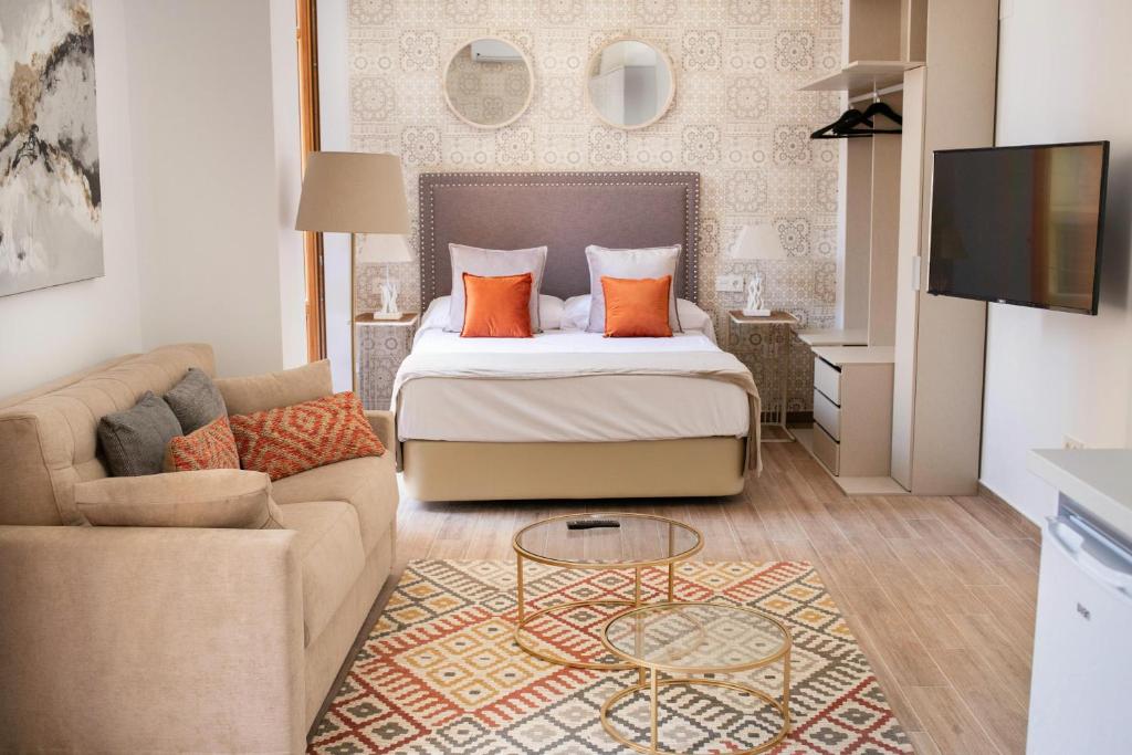 pokój hotelowy z łóżkiem i kanapą w obiekcie Feelathome Mártires Apartments w Maladze