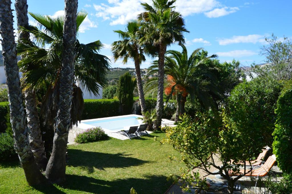 a yard with palm trees and a swimming pool at Villa Cerezos in Jávea