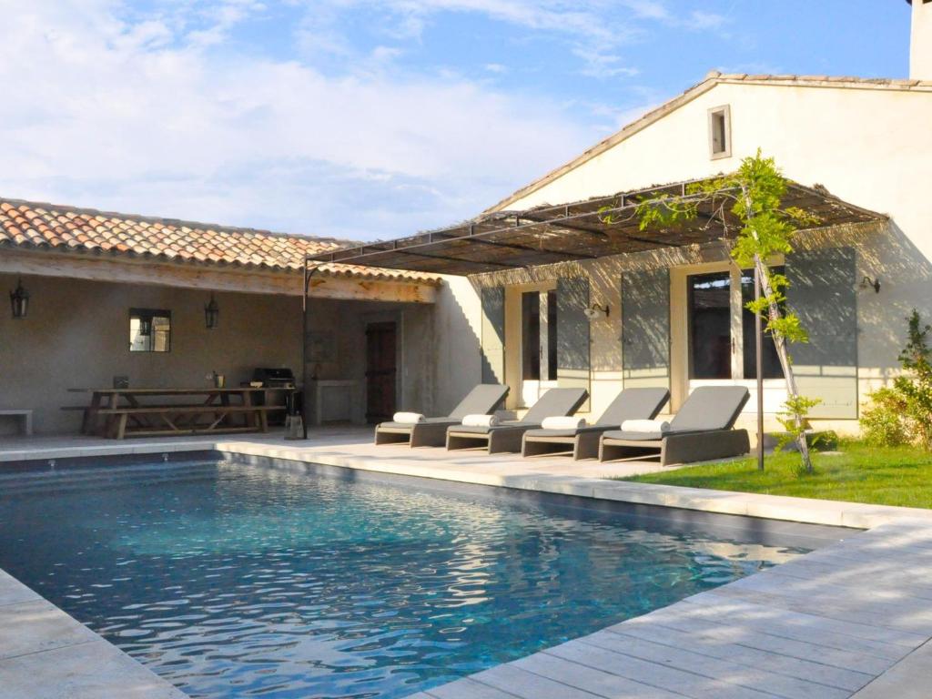 a swimming pool with chairs and a house at Grandeur Villa in Eygali res with Pool in Eygalières