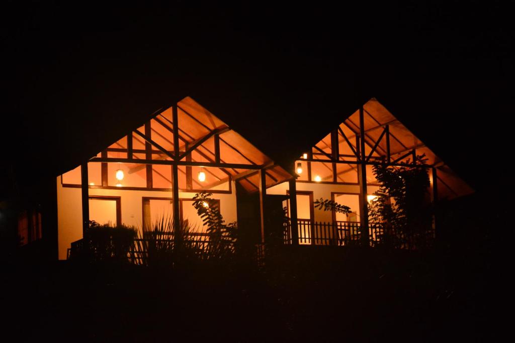 uma casa iluminada à noite no escuro em Rainforest Mount Lodge em Deniyaya