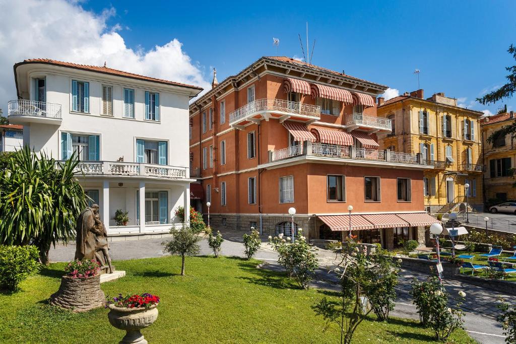 a group of buildings with a statue in a yard at Hotel Villa Maria in Sanremo