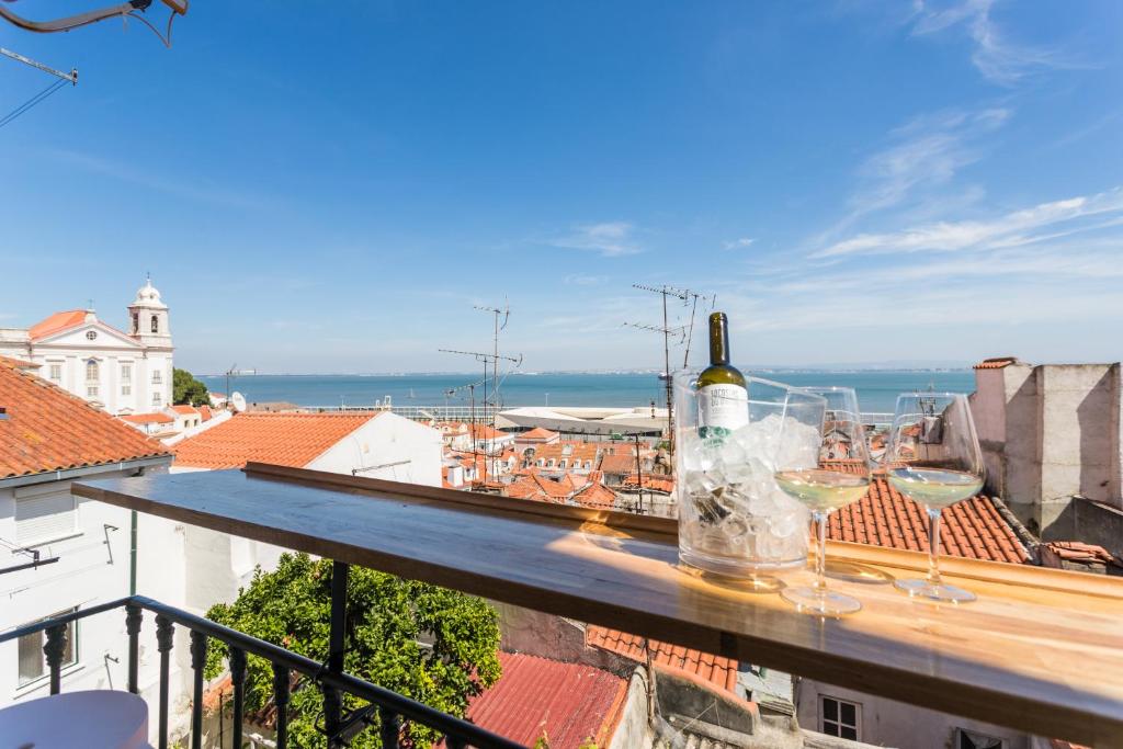 - une bouteille de vin et des verres sur le balcon dans l'établissement Alfama Vintage Studio Apartment w/ RiverView - by LU Holidays, à Lisbonne