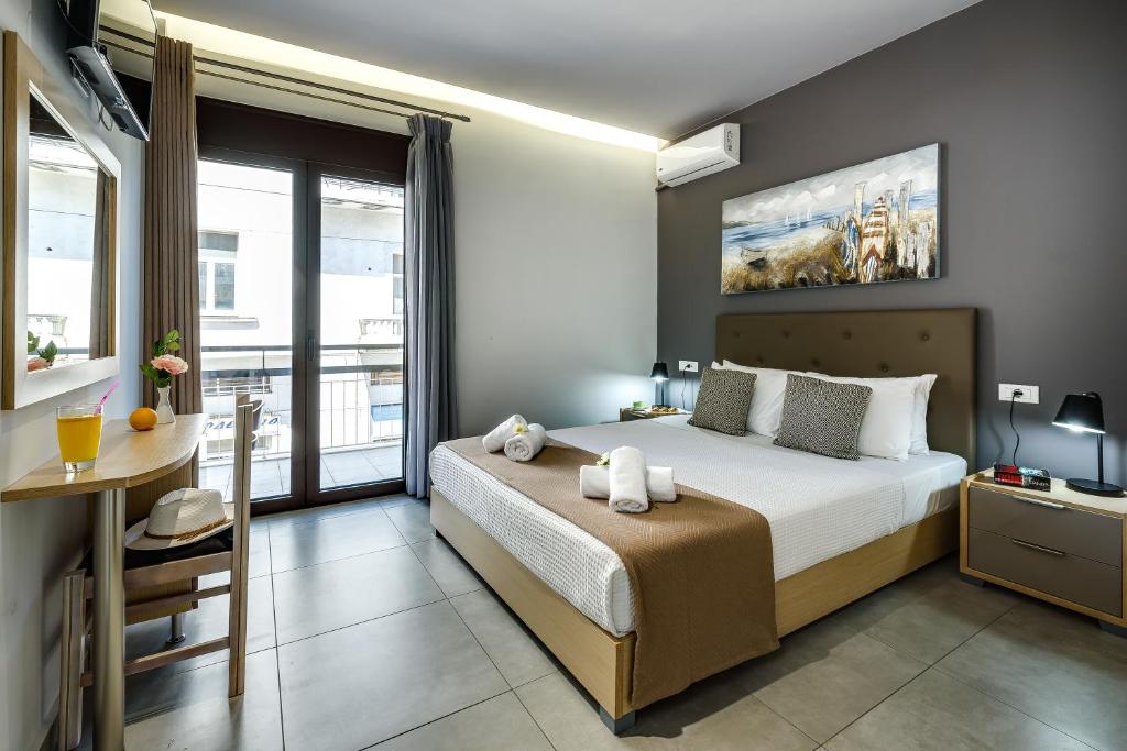 a bedroom with a bed and a table and a window at City Breeze Apartment in Chania Town