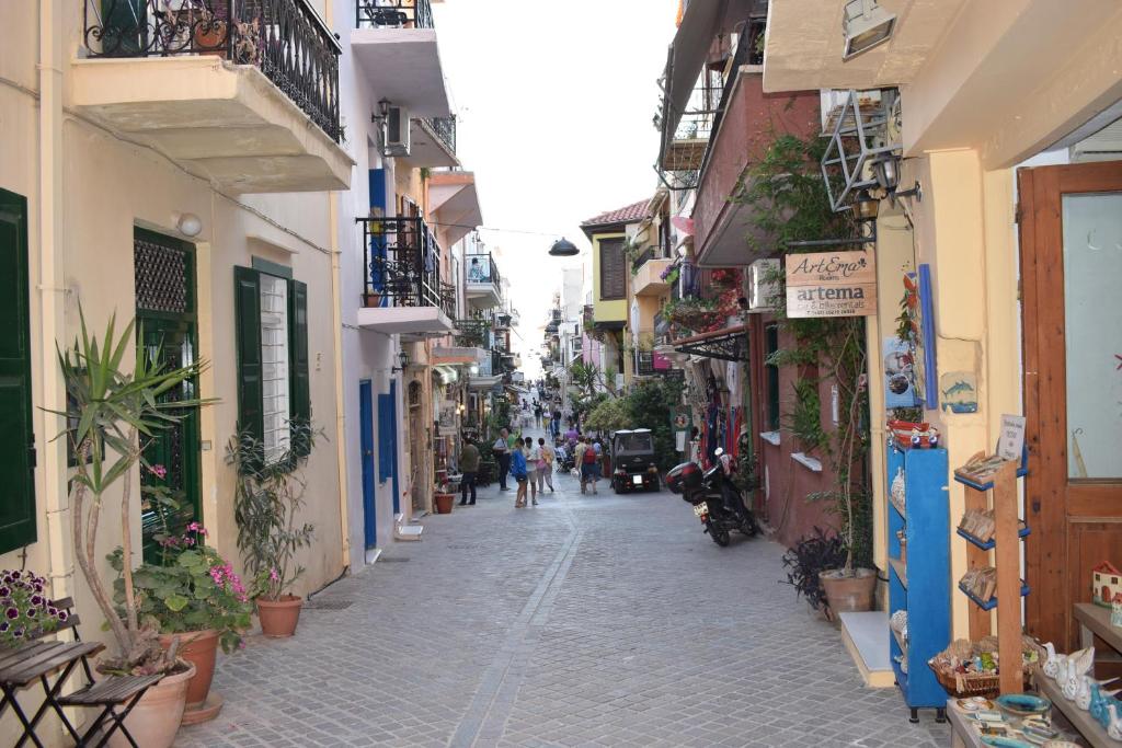 an alley with people walking down a street with buildings at Sofias Home in Chania Town