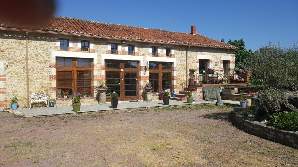 a large brick building with a bench in front of it at Le Patronage in Bazoges-en-Pareds