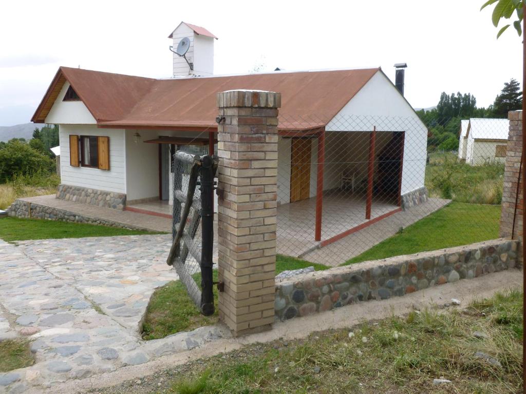 una casa con un molino de viento delante de ella en Cabañas del Sol en Potrerillos