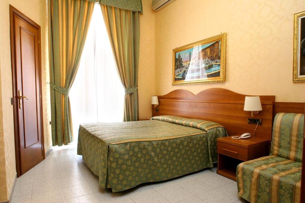 une chambre d'hôtel avec un lit et une chaise dans l'établissement Hotel Teti, à Rome