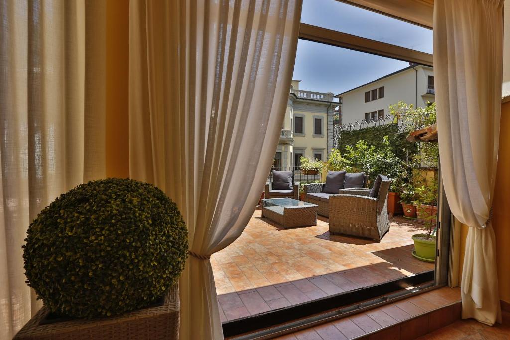 Blick auf eine Terrasse von einem Fenster mit Vorhängen in der Unterkunft Il Valentino Luxury Houses in Florenz