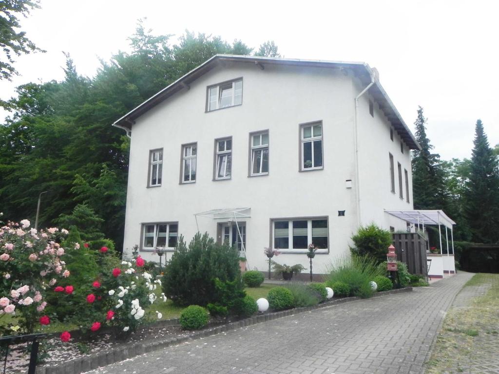 ein weißes Haus mit Blumen davor in der Unterkunft Ferienwohnungen Fiedler in Neuhof
