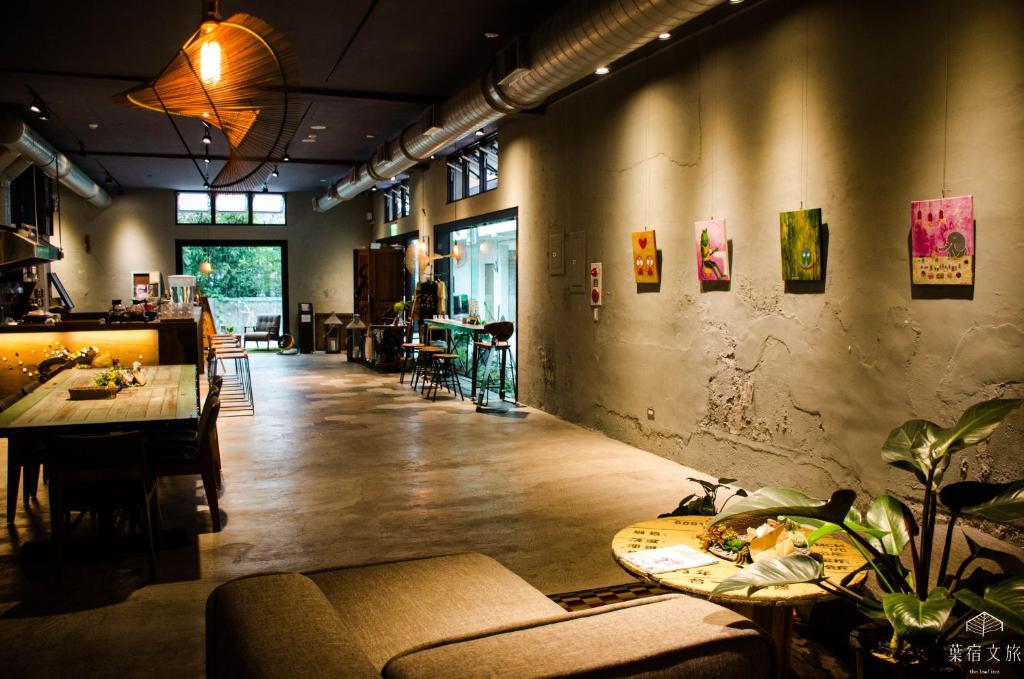 um restaurante com mesas e cadeiras num quarto em The Leaf Inn em Hualien City