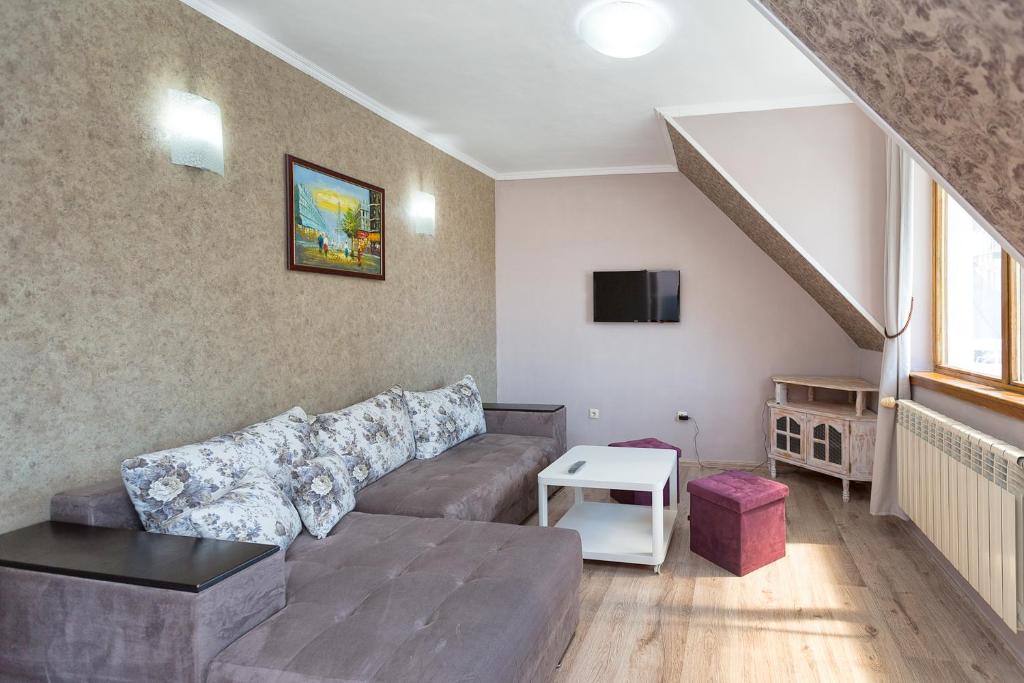 a living room with a couch and a staircase at Family Hotel Argo in Varna City