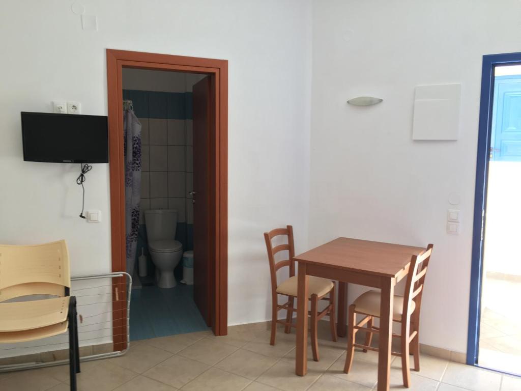 a dining room with a table and chairs and a toilet at Eugenia travasarou sea view appartments in Diakofti