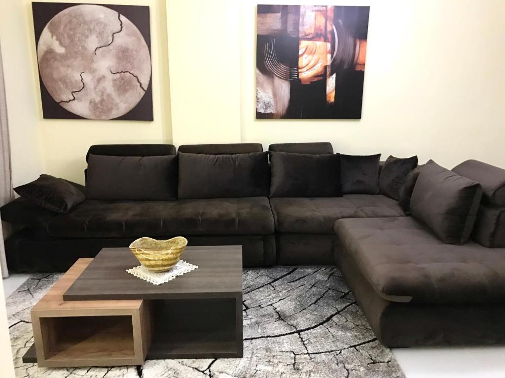 ein Wohnzimmer mit einem braunen Sofa und einem Couchtisch in der Unterkunft EKA Luxury Penthouse in Durrës