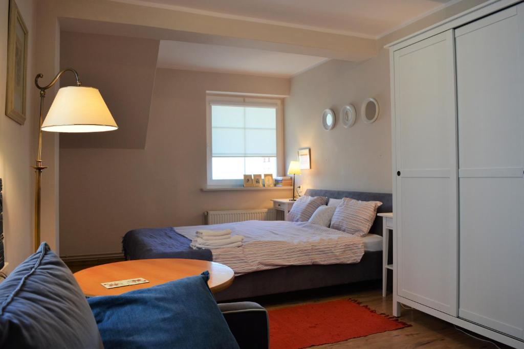 - une chambre avec un lit, un canapé et une fenêtre dans l'établissement Apartament Margarita, à Mrągowo