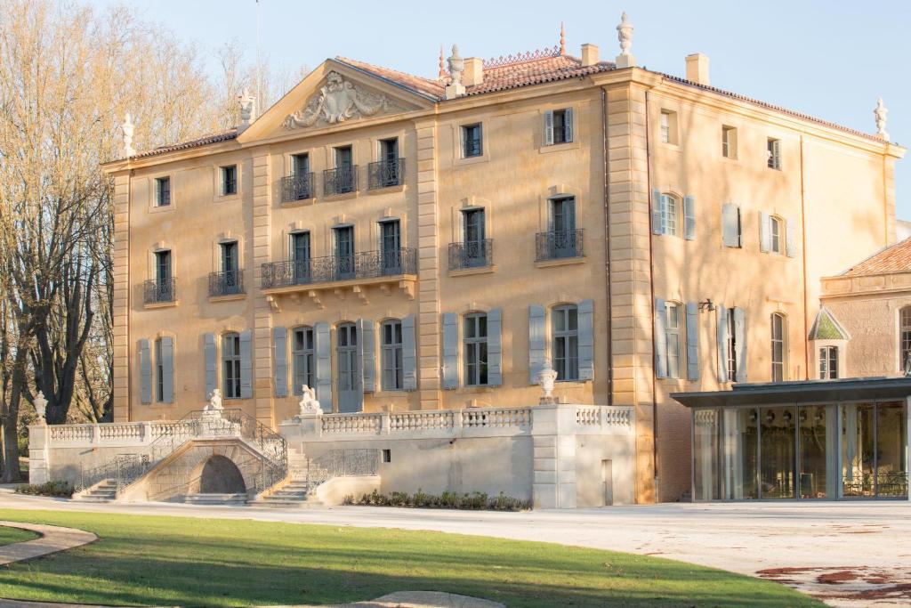 un grand bâtiment avec un pont en face dans l'établissement Château de Fonscolombe, à Le Puy-Sainte-Réparade