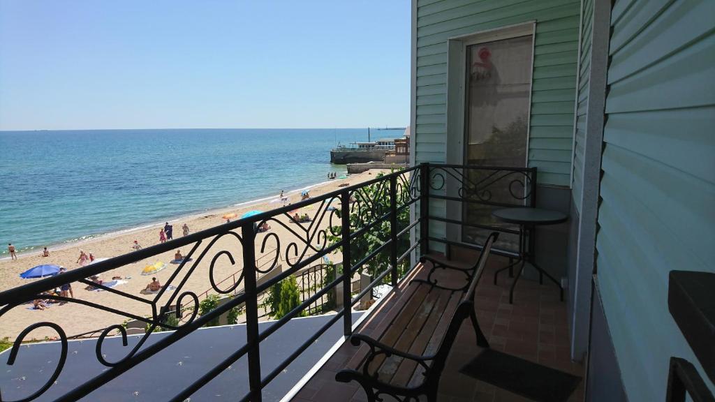 a balcony with two chairs and a view of the beach at Sauvignon-Zagara in Odesa