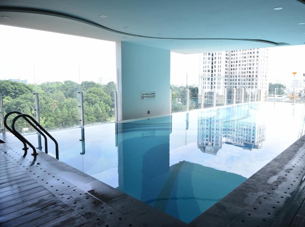 a swimming pool in a building with a large window at Andy studio-Orchard Garden-Airport- Gym & Pool in Ho Chi Minh City