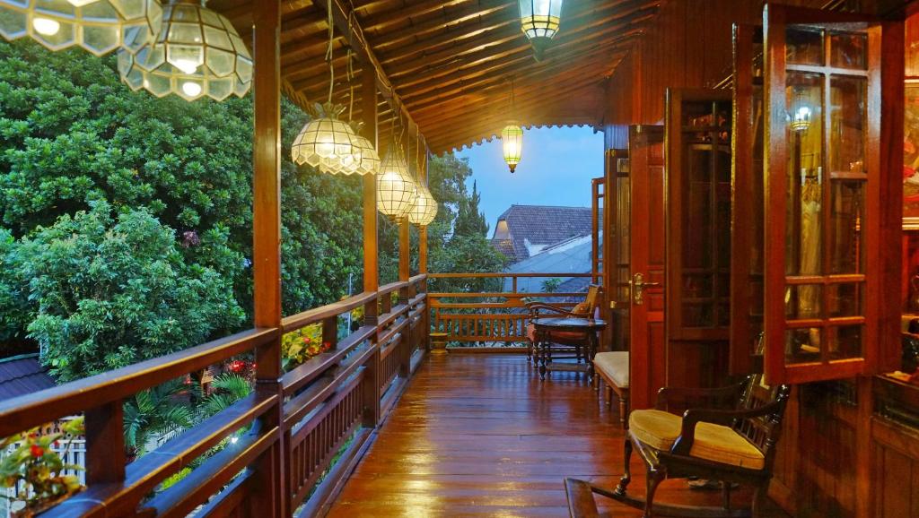 a balcony of a restaurant with chairs and lights at Badjoeri Ethnic Wooden Homestay in Bandung