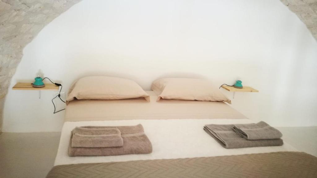 a bedroom with two beds with towels on the floor at Solis Domus - Meridies in Ostuni