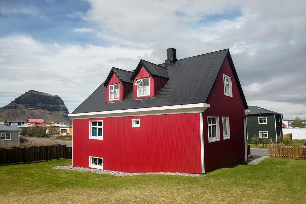 a red barn with a black roof at Grundarfjördur Hostel in Grundarfjordur