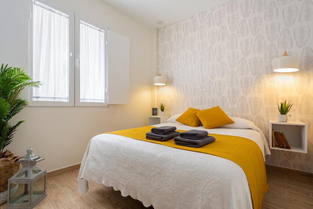 1 dormitorio con 1 cama con 2 toallas en Azafran Suites, en Sevilla