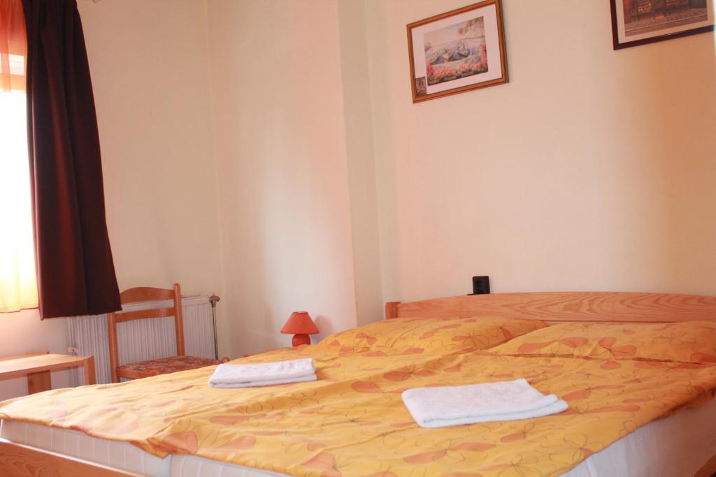 a bedroom with a bed with two towels on it at Király Szálló & Panzió in Nagykanizsa
