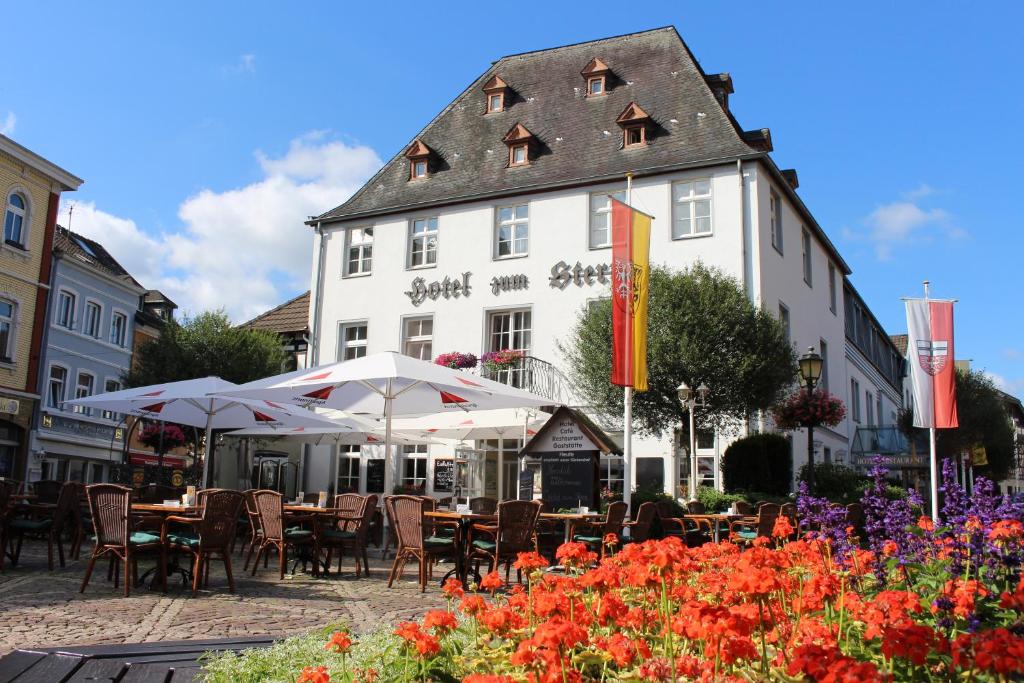 restauracja ze stołami i parasolami przed budynkiem w obiekcie Hotel Zum Stern w mieście Bad Neuenahr-Ahrweiler