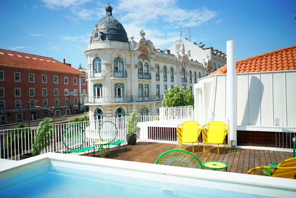 a balcony with yellow chairs and a building at Casas da Baixa - Vila Intendente in Lisbon