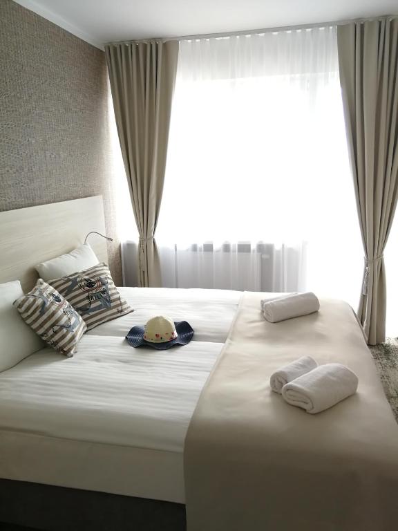 a bedroom with two beds with towels and a window at Willa Nest in Unieście