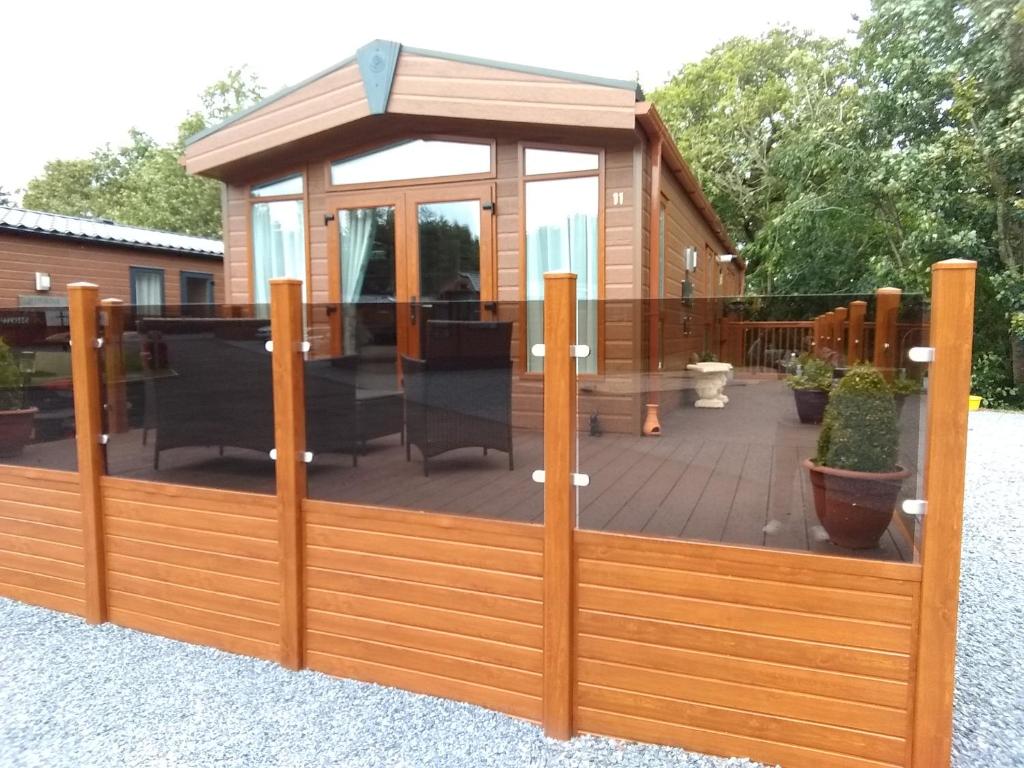 a wooden privacy fence with a gazebo at 11 Burnside Lodge in Auchterarder