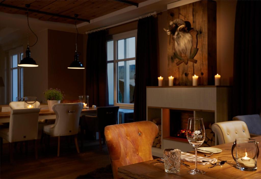 a dining room with a table and a fireplace at Hotel Zweite Heimat in Sankt Peter-Ording