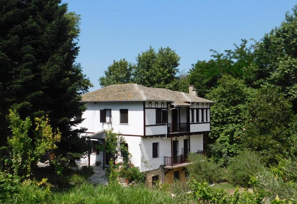 an old white house in the middle of trees at Guesthouse To kalivi in Chorefto