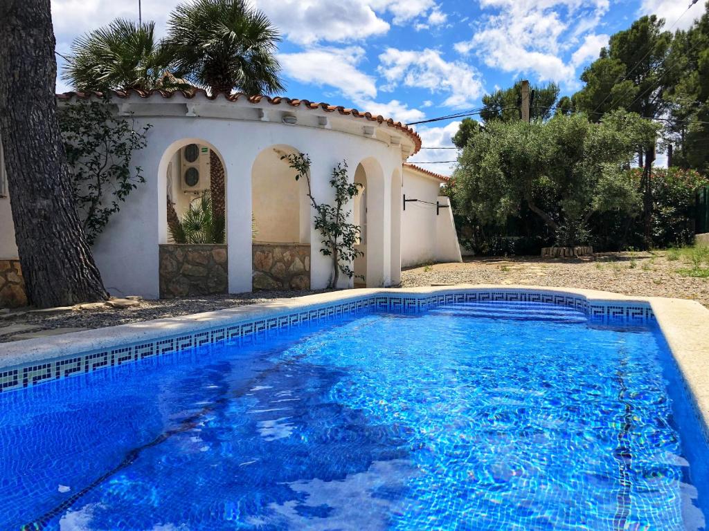 a swimming pool in front of a house at Rentalmar Villa Cristina Families Only in Miami Platja