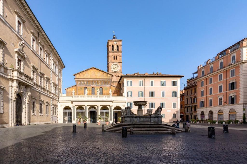 einen Stadtplatz mit einem Uhrturm und einem Brunnen in der Unterkunft Rome As You Feel - Ripa Apartments in Trastevere in Rom