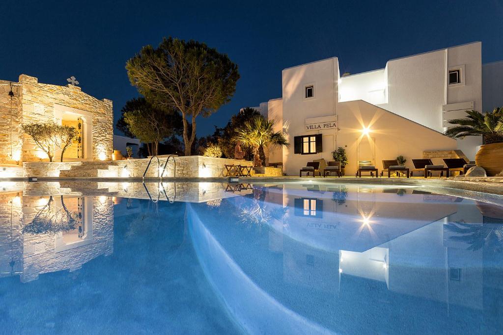 a swimming pool in front of a house at night at Villa Pela in Aliki