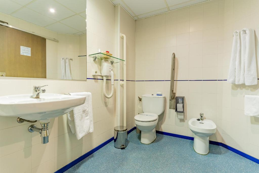 
a bathroom with a toilet, sink, and mirror at Hotel Monreal Jumilla in Jumilla
