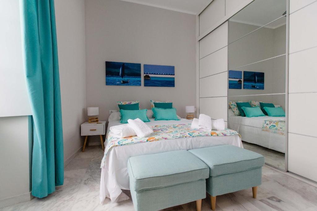カディスにあるApartamento La Casa del Almiranteの白いベッドルーム(青い枕のベッド2台付)