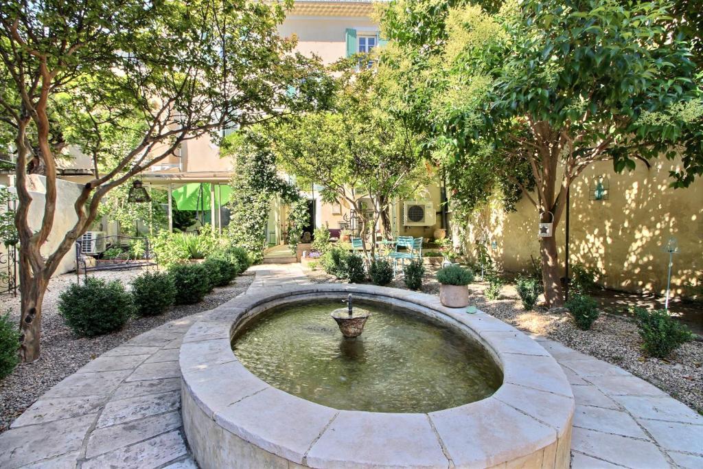 a large fountain in a courtyard with trees at Effets Personnels in Orange