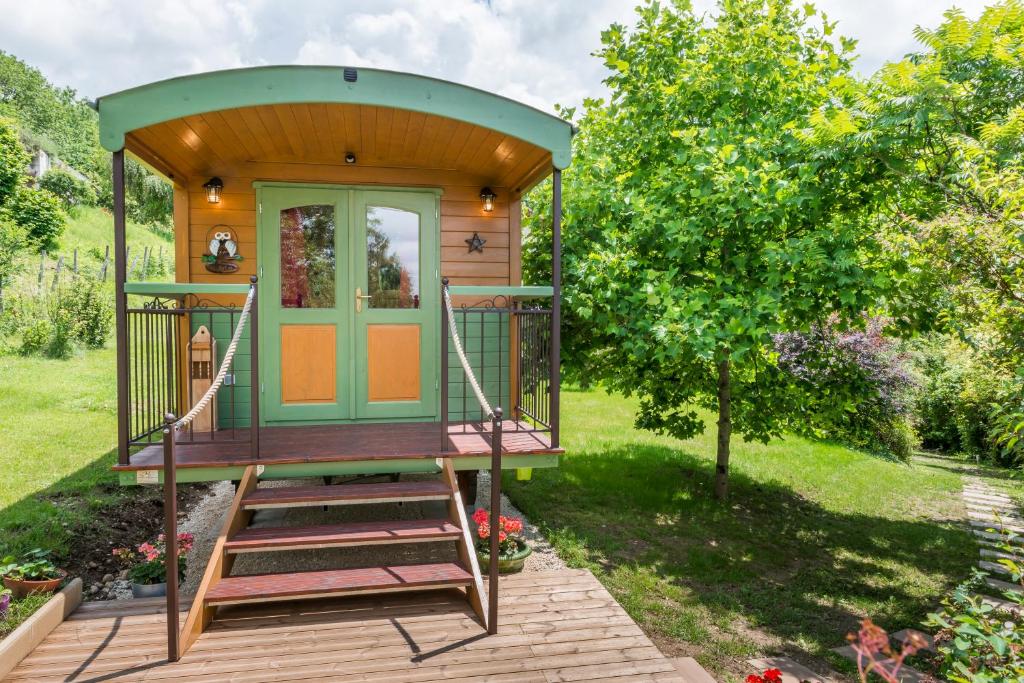une petite maison avec un escalier menant à la porte d'entrée. dans l'établissement ROULOTTE DE CHARME 