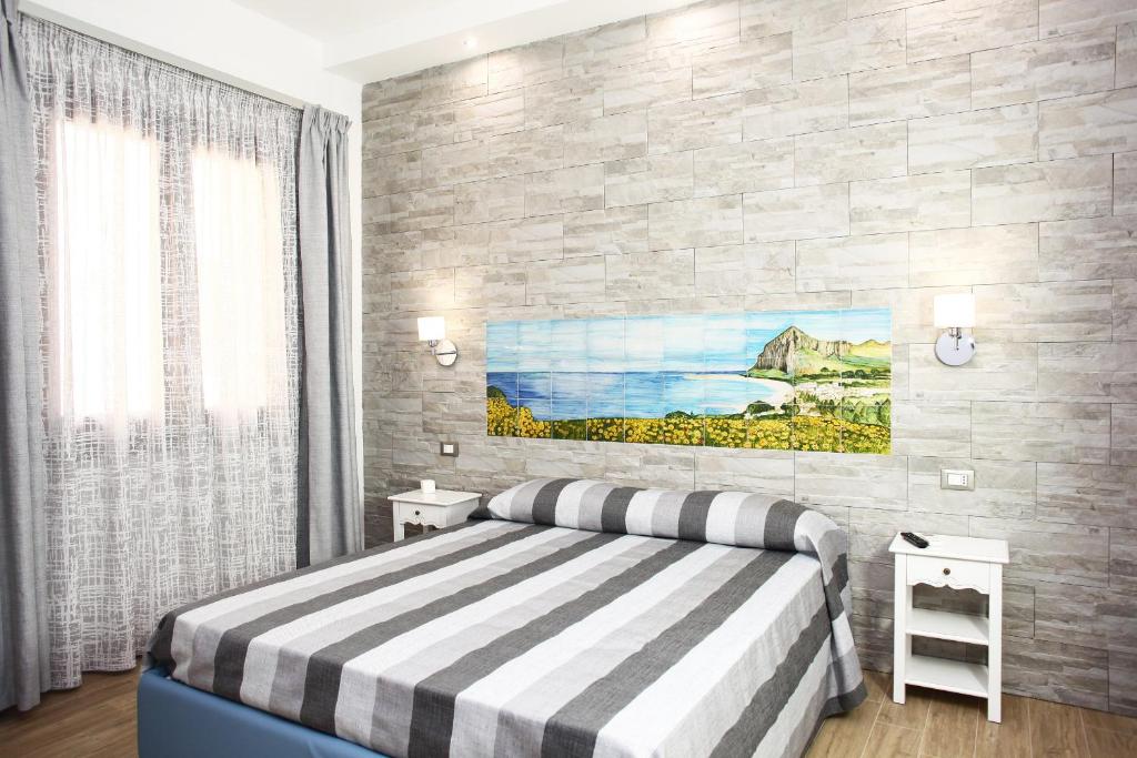 - une chambre avec un lit et une peinture murale dans l'établissement Ninni e Fede, à San Vito Lo Capo