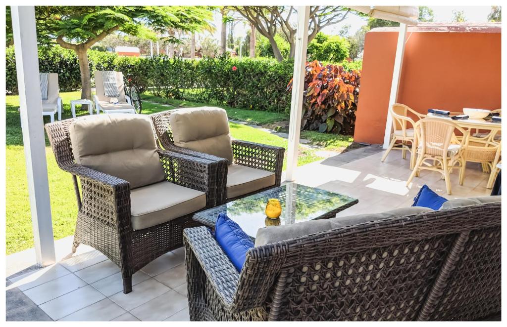 eine Terrasse mit 2 Korbstühlen und einem Tisch in der Unterkunft TC Bungalow Melocotones 15 in Maspalomas