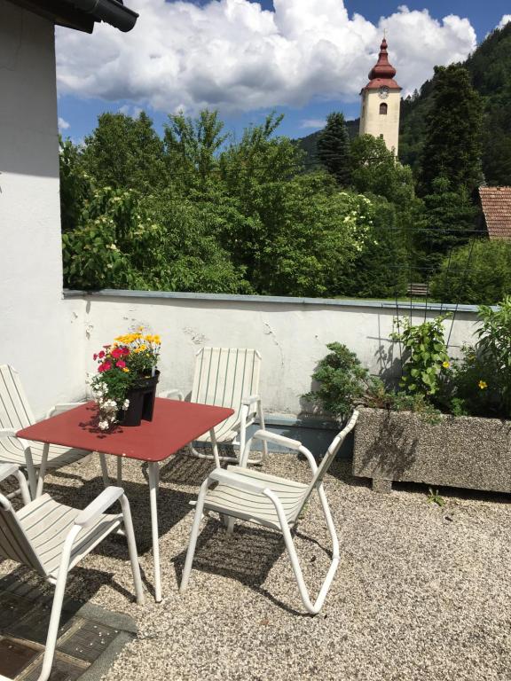 a red table and chairs on a patio with a lighthouse at Karls Ferienwohnung mit Terrasse in Teufenbach